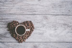 Coffee cup on coffee beans in the shape of a heart